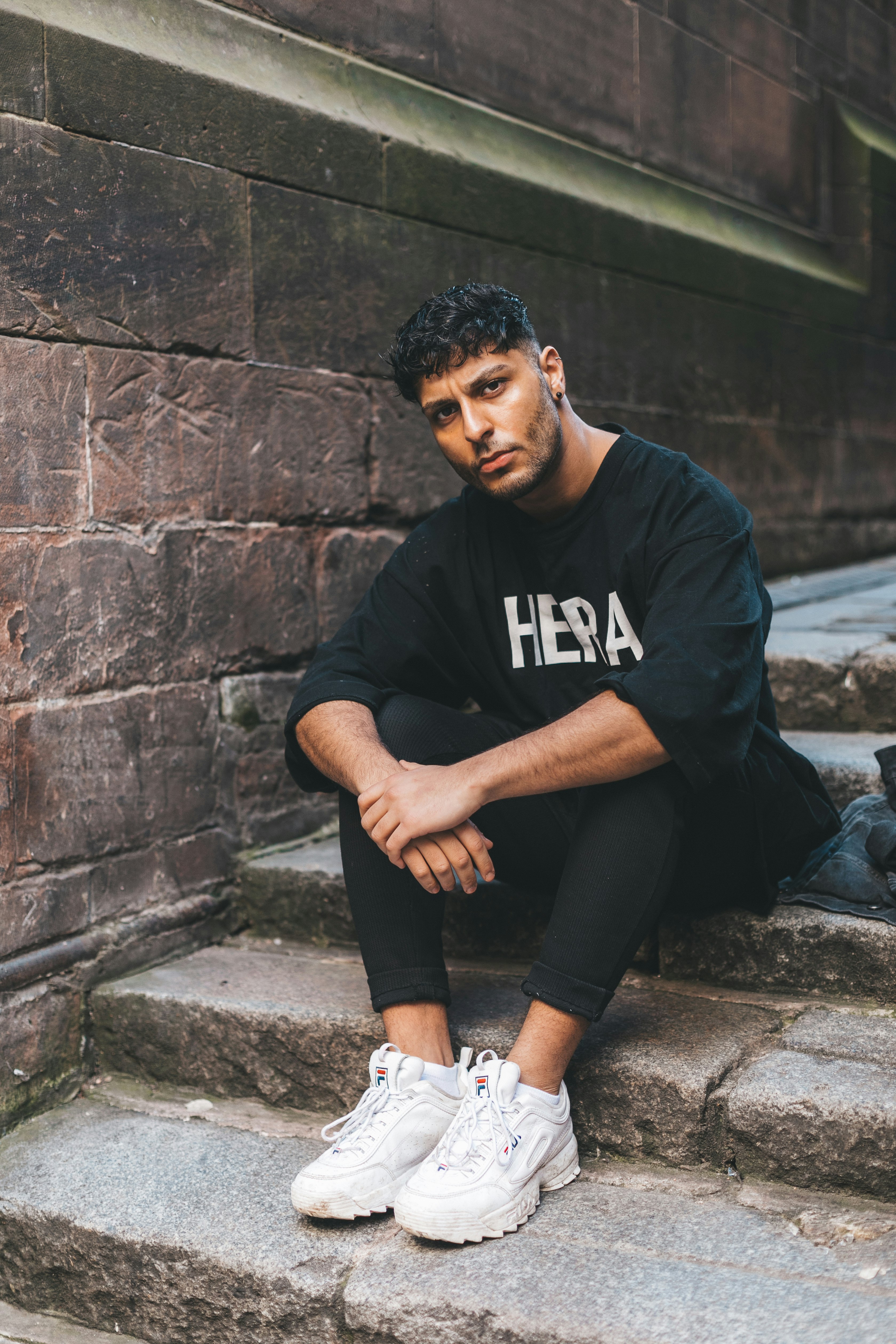 man in black sits on stair steps